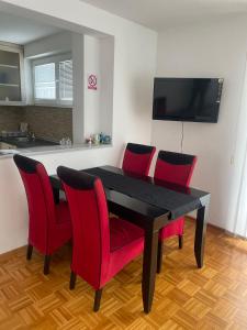 einen schwarzen Tisch und rote Stühle in der Küche in der Unterkunft Aprtments Belma in Sarajevo