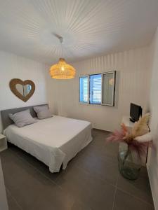 um quarto com uma cama e um lustre em Appart avec terrasse vue sur mer exceptionnelle em L'Île-Rousse