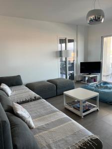 uma sala de estar com um sofá e uma mesa em Appart avec terrasse vue sur mer exceptionnelle em L'Île-Rousse