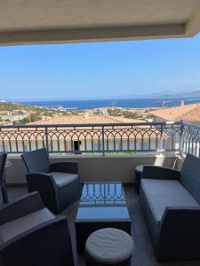 balkon z kanapami i widokiem na ocean w obiekcie Appart avec terrasse vue sur mer exceptionnelle w mieście LʼÎle-Rousse