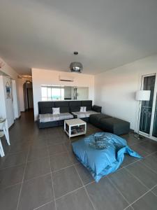 salon z kanapą i stołem w obiekcie Appart avec terrasse vue sur mer exceptionnelle w mieście LʼÎle-Rousse