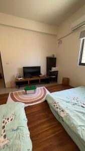een kamer met twee bedden en een tafel erin bij Dou Dou Long Homestay in Donggang