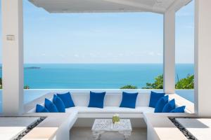 sala de estar con sofá blanco y almohadas azules en BLUE ELEPHANT Luxury Pool Villa Koh Samui by Blue Mountain Villas en Koh Samui