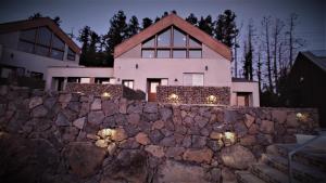 a house behind a stone wall at night at Walden Studios in Seogwipo