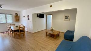 a living room with a table and a dining room at Appartement idéal pour été et hiver, situé au pied des pistes de ski et des sentiers de randonnée in Prémanon