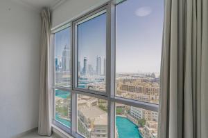 a room with a large window with a view of a city at Splendid Apartments with Burj Khalifa and Fountain View in Dubai