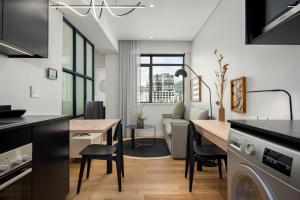 a kitchen and living room with a table and a dining room at The Carrington Aparthotel by Totalstay in Cape Town