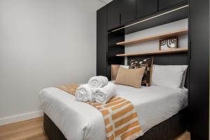a bedroom with a large bed with towels on it at The Carrington Aparthotel by Totalstay in Cape Town