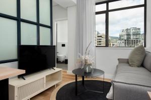a living room with a tv and a couch at The Carrington Aparthotel by Totalstay in Cape Town