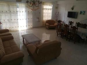 sala de estar con sofá, sillas y mesa en Villa Fleurie : Belle Maison ensoleillée en Pointe aux Piments