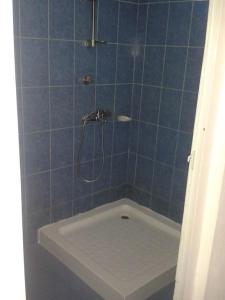 een blauwe betegelde badkamer met een douche en een bad bij Villa Fleurie : Belle Maison ensoleillée in Pointe aux Piments