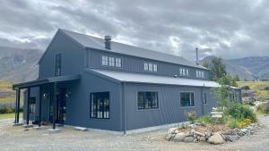 a blue house with a lot of windows at The Barn at Killin B&B in Ohau