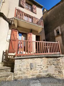 a building with a wooden balcony on the side of it at gîte la tanière de claire in Ségur