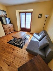 ein Wohnzimmer mit einem Sofa und einem Couchtisch in der Unterkunft gîte la tanière de claire in Ségur