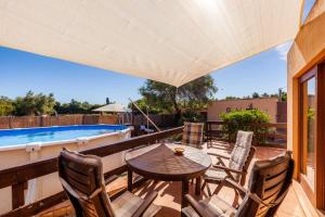 a patio with a table and chairs and a swimming pool at Apartment Tina Capdepera in Capdepera