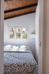 a white bedroom with a bed and two windows at Terrazza San Saba in Rome