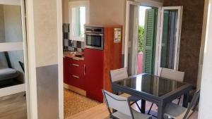 una piccola cucina con tavolo e frigorifero rosso di Appartement résidence avec piscine a Calvi