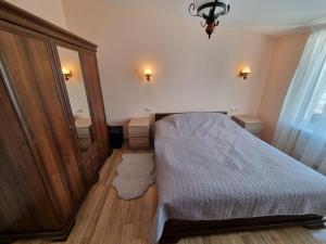 een kleine slaapkamer met een bed en een spiegel bij Neringa apartamentai in Palanga