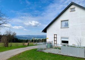 a white house with a fence next to a road at Ferienhaus Frieda 