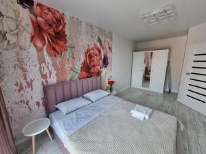 1 dormitorio con 1 cama y una pintura en la pared en Dream town Apartaments біля залізничного вокзалу en Lutsʼk