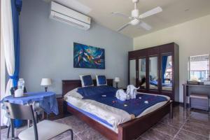 a bedroom with a bed and a ceiling fan at Chalong Palm Residence in Chalong 