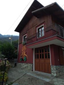 a red house with a balcony on top of it at Casa Pradarèire in Fenestrelle