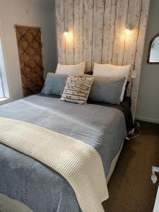 a bedroom with a large bed with pillows on it at Adorable Beach Unit Stanmore Bay in Whangaparaoa