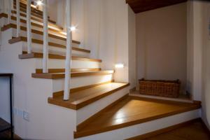 - un escalier dans une maison dotée de parquet et de murs blancs dans l'établissement Casa Pastello in Valpolicella, à Cavalo