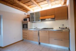 a kitchen with wooden cabinets and stainless steel appliances at Casa Pastello in Valpolicella in Cavalo