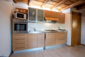 a kitchen with wooden cabinets and a stove top oven at Casa Pastello in Valpolicella in Cavalo