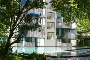 an apartment building with a swimming pool in front of it at The deck condominium by Ryan, walking to patong beach in Patong Beach