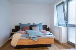 1 dormitorio con 1 cama con almohadas azules en Samoobslužné Apartmány Evičenstvo en Třinec