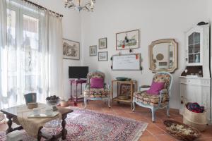 een woonkamer met 2 stoelen, een tafel en een spiegel bij Casina di Marnie in Balestrate