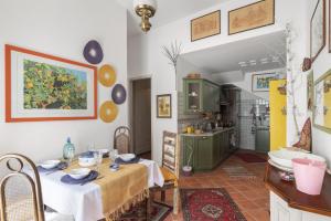 a dining room with a table and a kitchen at Casina di Marnie in Balestrate