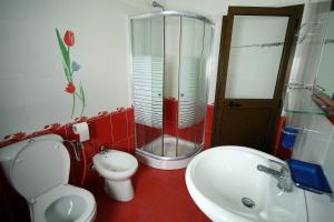 uma casa de banho com um WC, um chuveiro e um lavatório. em King's Star Hotel em Velipojë