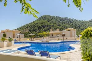 a resort pool with chairs and a mountain in the background at Buena Vista G5 in Atamaría