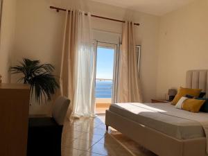 - une chambre avec un lit et une vue sur l'océan dans l'établissement Theona Apartments, à Saranda