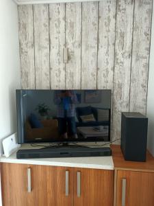 a flat screen tv sitting on top of a cabinet at Adorable Beach Unit Stanmore Bay in Whangaparaoa