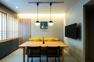 a dining room with a wooden table and yellow chairs at Section L Tsukiji in Tokyo