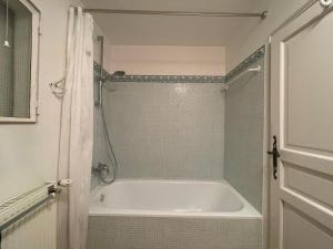 a bathroom with a white tub and a shower at Appartement près de DOLE in Menotey