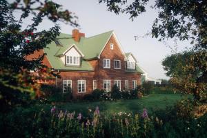 a large red brick house with a green roof at Bauernhof Wulff - Fewo "Amrum" in Reußenköge