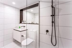 a white bathroom with a shower and a toilet at Panorama Apartment Walk to Box Hill Central by GoodLive in Box Hill +14 photos