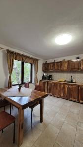 una cucina con tavolo in legno e una sala da pranzo di Conacul din Pădure a Poiana Mărului