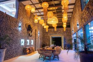 comedor con mesa, sillas y lámparas de araña en BLUE ELEPHANT Luxury Pool Villa Koh Samui by Blue Mountain Villas en Koh Samui