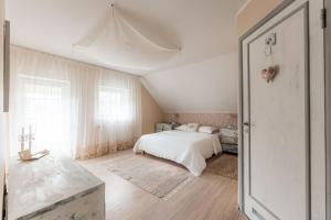 a white bedroom with a bed and a window at Lovely spacious apartment in the city center in Kuressaare