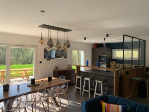 cocina y sala de estar con mesas y sillas de madera en La cabane des écureuils, en Xonrupt-Longemer