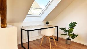 einen schwarzen Schreibtisch in einem Zimmer mit Fenster in der Unterkunft Suite-Apartment zentral in Krefeld mit hohen Decken in Krefeld