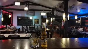 eine Flasche Bier auf einem Tisch in einem Restaurant in der Unterkunft Coron Town Traveller's Dormitory in San Nicolas