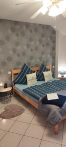 ein Schlafzimmer mit einem Bett mit blauen Kissen darauf in der Unterkunft Pension Deerkemer Kuh in Dorn-Dürkheim