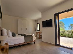 1 dormitorio con 1 cama y puerta corredera de cristal en Suite Sieste en Provence, en Entrecasteaux